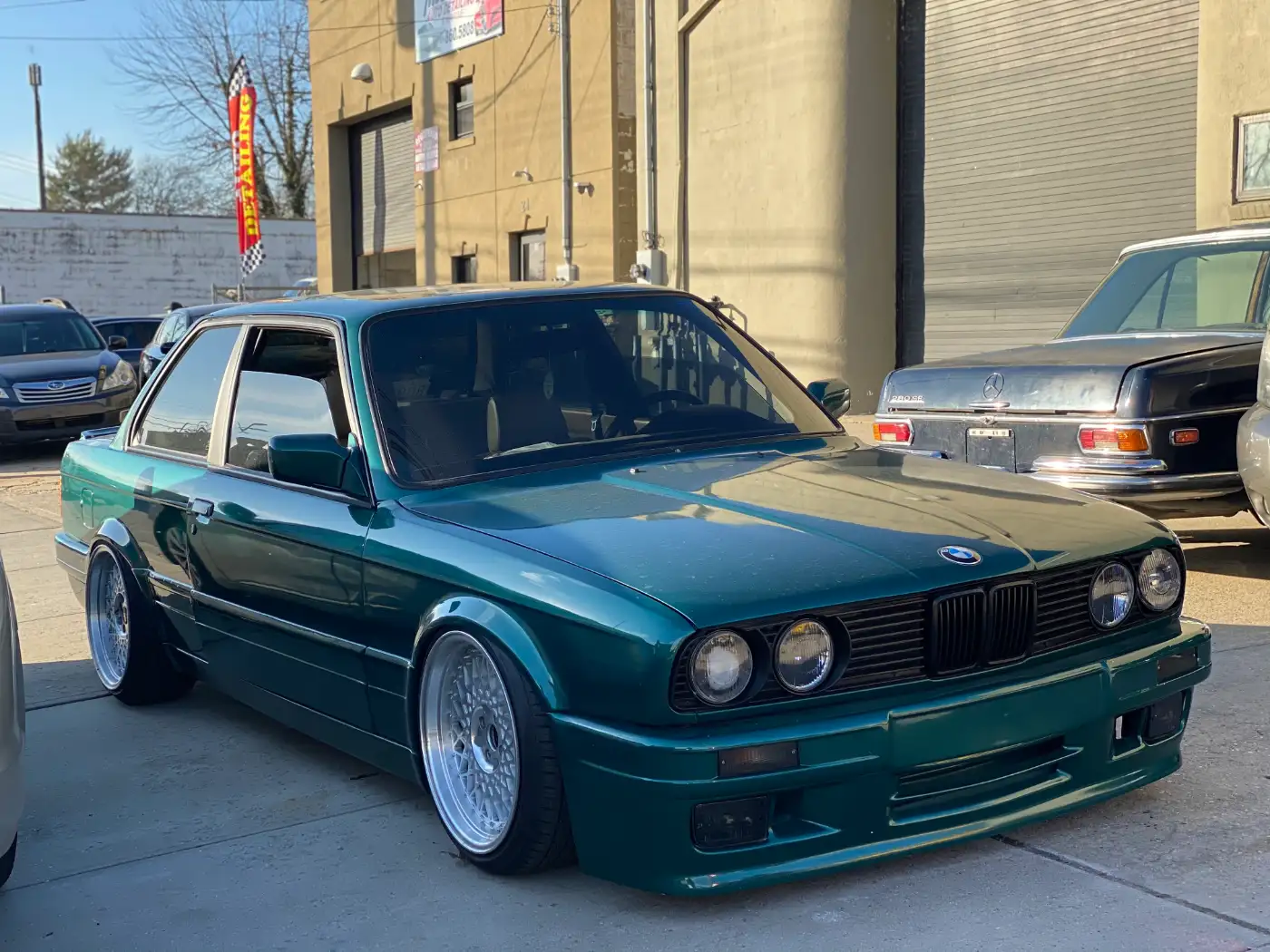 Green BMW E30 on polished wheels